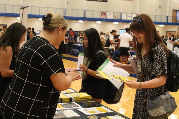 Senior Tori Jo Smith visits with a college recruiter at the College and Career Fair. The fair was held in the big gym on Sept. 19.